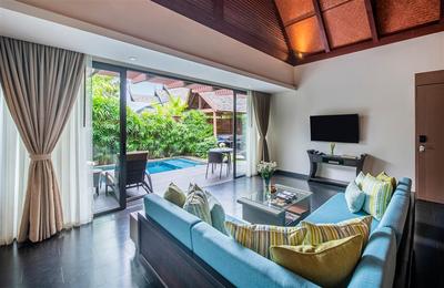 Living room with corner sofa and pool view