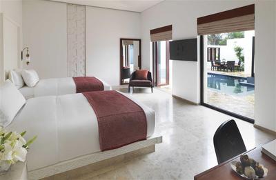 Twin bedroom with television and view of the pool