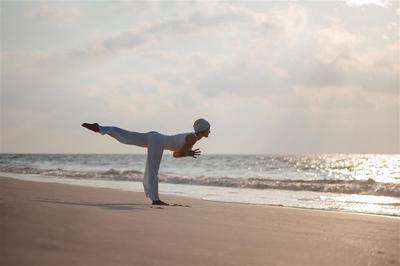 Spa instructor doing yoga on shoreline